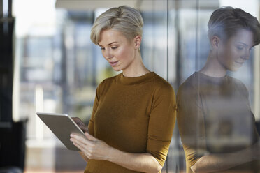 Geschäftsfrau mit Tablet am Fenster - RBF06967