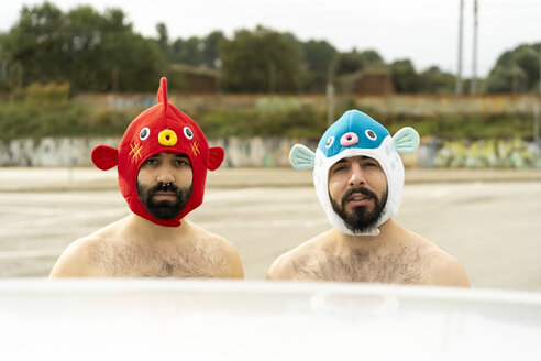 Portrait of shirtless gay couple wearing animal hats outdoors - AFVF02181