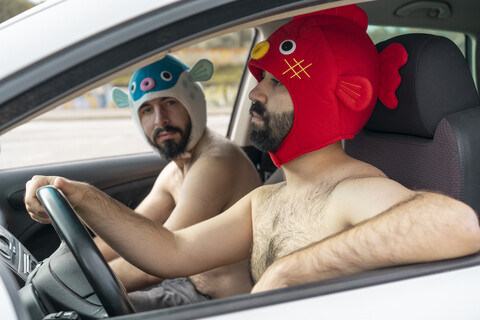 Schwules Paar in einem Auto mit Tierhüten, lizenzfreies Stockfoto