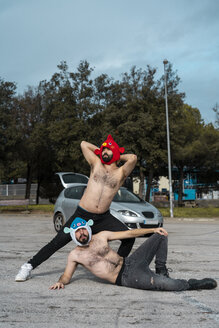 Gay couple wearing animal hats posing at car park - AFVF02185