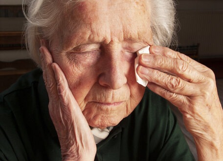 Ältere Frau wischt sich die Tränen mit einem Taschentuch ab - WWF04581