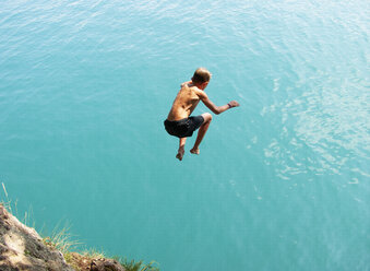 Boy having fun, jumping into Lake Wolfgangsee, Austria - WWF04585