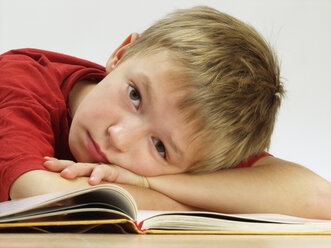 Gelangweilter Junge liest Schulbuch - WWF04592