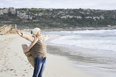Spain, Menorca, happy senior man standing at seashore in winter - IGGF00698