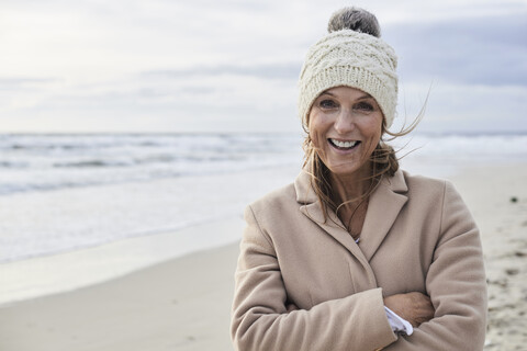 Spanien, Menorca, Porträt einer glücklichen älteren Frau am Strand im Winter, lizenzfreies Stockfoto