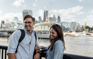 Großbritannien, London, lächelndes Paar mit Skyline im Hintergrund - MGOF03898