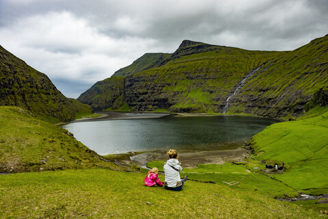 Dänemark, Färöer Inseln, Streymoy, Frau mit ihrer Tochter schaut zum Fjord von Saksun, lizenzfreies Stockfoto