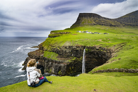 Denmark, Faroe islands, Vagar, Woman and her daughter looking at the Gasadalur waterfall stock photo
