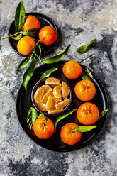 Tangerines with leaves, on plate and pieces in bowl - SARF04040