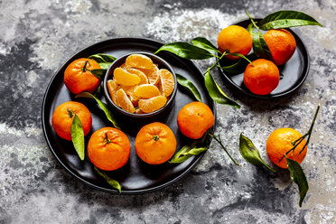 Tangerines with leaves, on plate and pieces in bowl - SARF04041