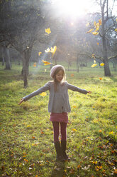 Young girl on meadow in autumn, autumn leaves - LVF07628