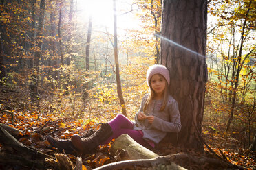 Young girl sitting on tree in autumn - LVF07632