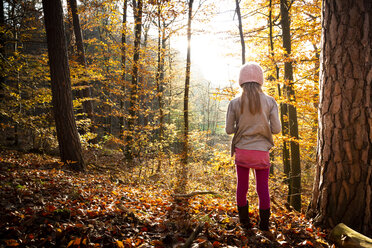 Young girl standing alone in autumn forest, rear view - LVF07634