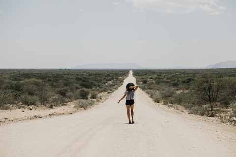 Namibia, Frau zu Fuß auf der Straße zur Spitzkoppe, lizenzfreies Stockfoto