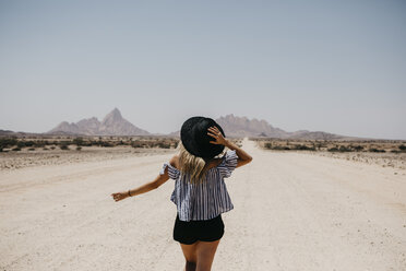 Namibia, woman walking on the road to Spitzkoppe - LHPF00343