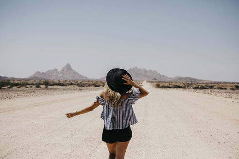 Namibia, Frau zu Fuß auf der Straße zur Spitzkoppe - LHPF00343