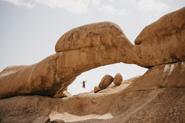 Namibia, Spitzkoppe, woman jumping at rock formation - LHPF00349