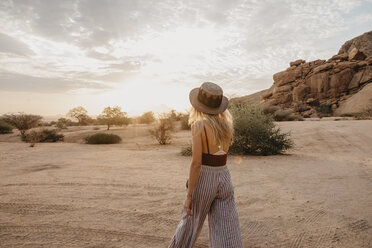 Namibia, Spitzkoppe, Rückansicht einer Frau mit Hut bei Sonnenuntergang - LHPF00360