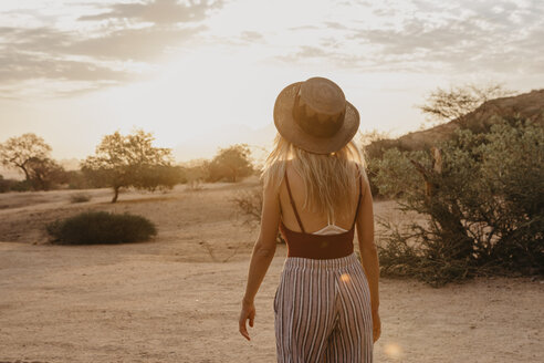 Namibia, Spitzkoppe, Rückansicht einer Frau mit Hut bei Sonnenuntergang - LHPF00361
