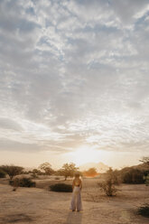 Namibia, Spitzkoppe, Frau steht in Wüstenlandschaft bei Sonnenuntergang - LHPF00363