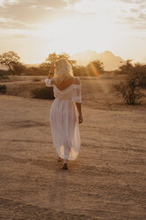 Namibia, Spitzkoppe, Rückansicht einer Frau bei Sonnenuntergang in der Wüstenlandschaft - LHPF00365