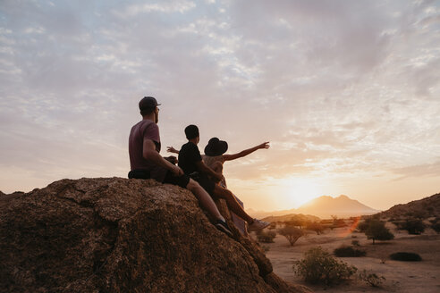 Namibia, Spitzkoppe, friends sitting on a rock watching the sunset - LHPF00370