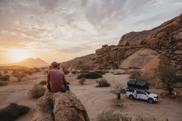 Namibia, Spitzkoppe, Freunde sitzen auf einem Felsen und beobachten den Sonnenuntergang - LHPF00371