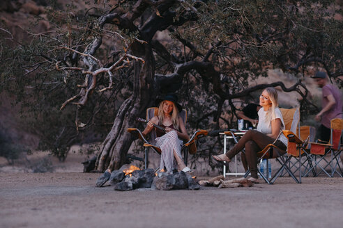 Namibia, Freunde sitzen am Lagerfeuer und spielen Gitarre - LHPF00382