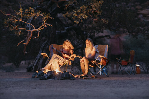Namibia, Freunde sitzen am Lagerfeuer und spielen Gitarre - LHPF00383