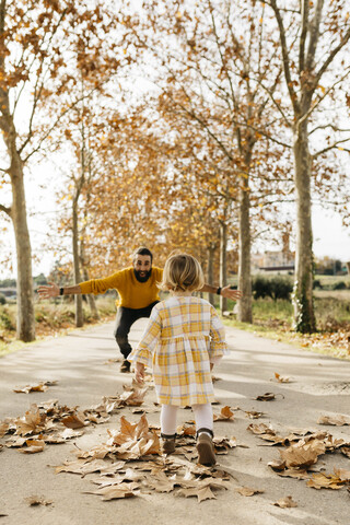 Vater und Tochter genießen einen morgendlichen Tag im Park im Herbst, lizenzfreies Stockfoto