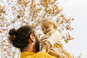 Father holding his daughter in the morning, in a park in autumn - JRFF02276