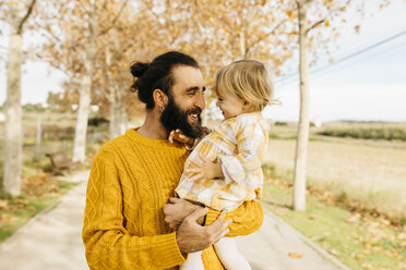 Father carrying his daughter on a morning day in the park in autumn - JRFF02280