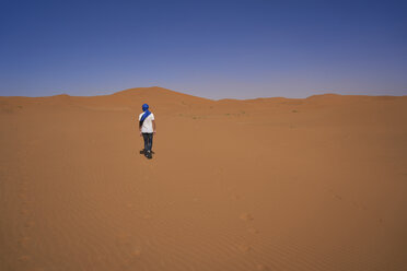 Morocco, back view of man walking on desert dune - EPF00513