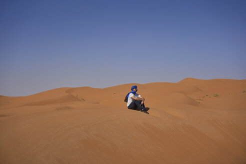 Marokko, Mann sitzt auf einer Wüstendüne und betrachtet die Aussicht - EPF00518