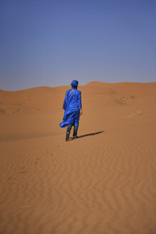 Marokko, Rückenansicht eines Mannes mit blauem Kaftan und Turban auf einer Wüstendüne - EPF00519