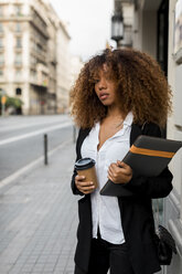Young woman with laptop bag and coffee to go in the city - MAUF02132