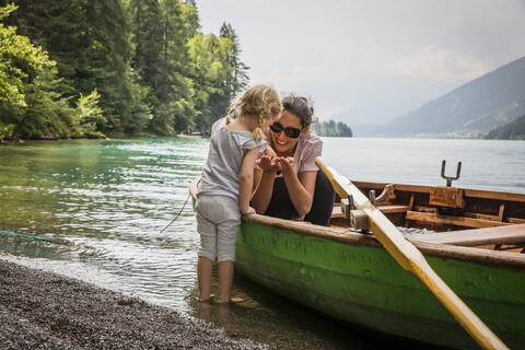 Österreich, Kärnten, Weissensee, Mutter im Ruderboot mit Tochter am Seeufer, lizenzfreies Stockfoto