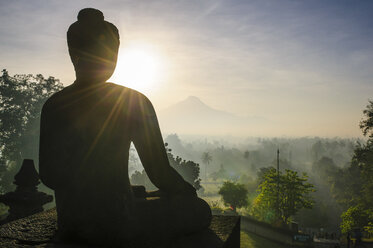 Indonesien, Java, Borobudur-Tempelkomplex, sitzender Buddha im Gegenlicht - RUNF00616