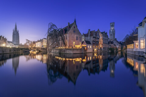 Belgien, Brügge, Grachtenufer und historische Gebäude bei Nacht, lizenzfreies Stockfoto