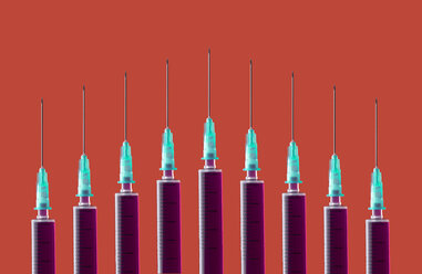 Multiple syringes organized in a pattern over orange background - DRBF00119