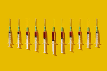 Multiple syringes organized in a pattern over yellow background - DRBF00121