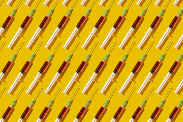 Multiple syringes organized in a pattern over yellow background - DRBF00122