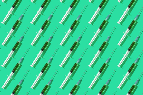Mehrere Spritzen in einem Muster über grünen Hintergrund organisiert, lizenzfreies Stockfoto