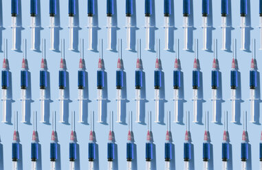 Multiple syringes organized in a pattern over blue background - DRBF00125