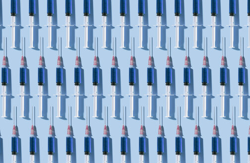 Multiple syringes organized in a pattern over blue background - DRBF00125
