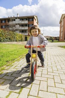 Glückliches Kleinkind mit Gleichgewichtsfahrrad auf einem Weg - MGIF00298