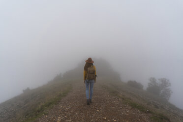 Frau beim Wandern im Nebel, auf einem Bergpfad gehend - AFVF02189