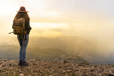 Frau mit Rucksack, auf einem Berg stehend, mit Blick auf die Aussicht - AFVF02194