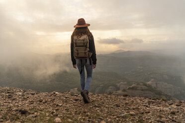 Frau mit Rucksack, auf einem Berg stehend, mit Blick auf die Aussicht - AFVF02195