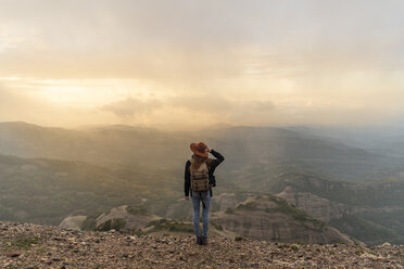 Frau mit Rucksack, auf einem Berg stehend, mit Blick auf die Aussicht - AFVF02197